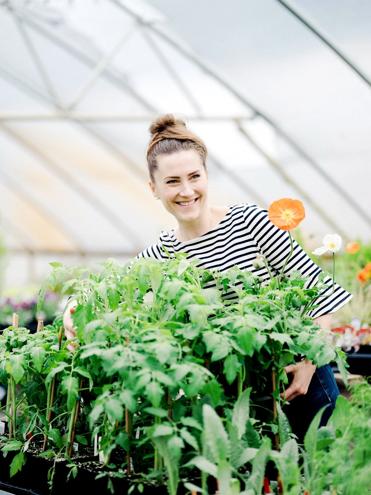 Liz Carter surrounded by handcrafted paper flowers in her greenhouse studio